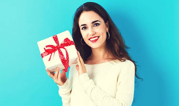 istock Young woman holding a gift box 620991108