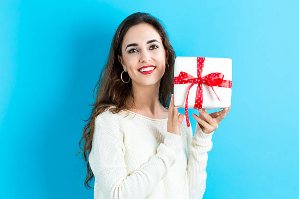 istock Young woman holding a gift box 620991122