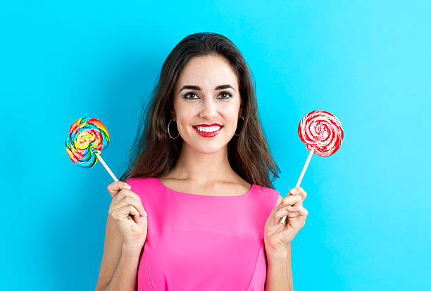 istock Young woman holding lollipops 620991126