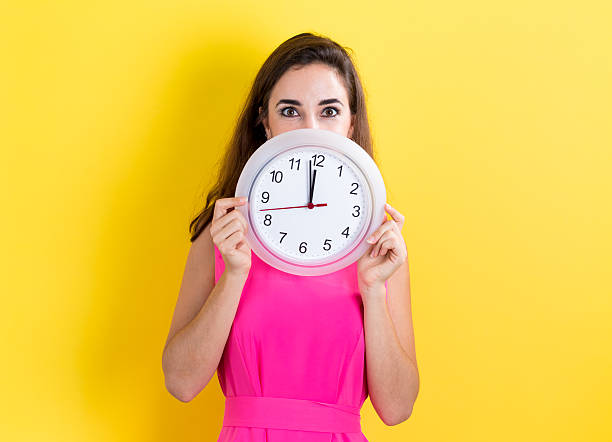 istock Woman with clock showing nearly 12 620991418