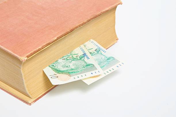 istock South African Rand in book isolated on white 620992124