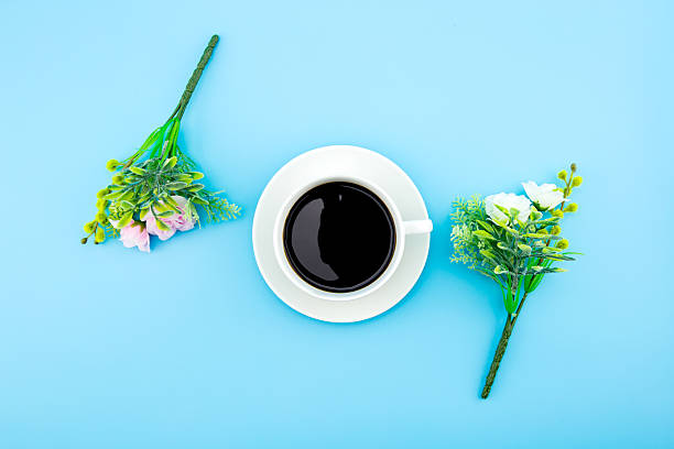 istock Cup of coffee surrounded by artificial flowers, Flat Lay. 620993492