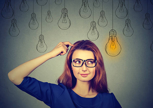 istock woman in glasses looking up at light idea bulb 620996812