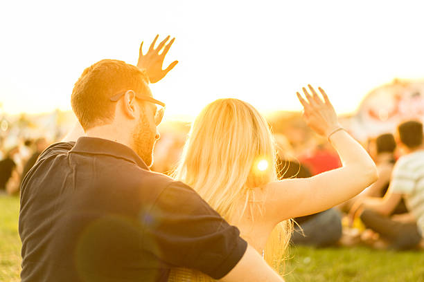 istock young couple at open air rock concert waving hands 621104202
