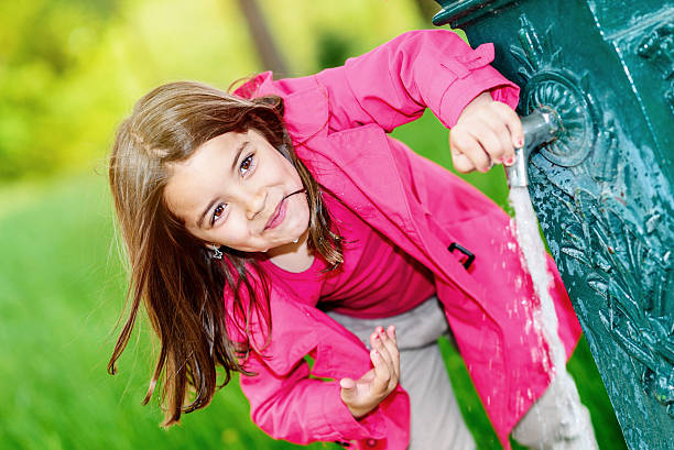 portrait of kid about to drink water in a fountain