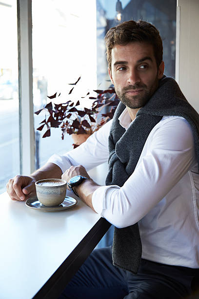 mężczyzna siedzący w kawiarni, patrzący w przyszłość - open necked shirt zdjęcia i obrazy z banku zdjęć