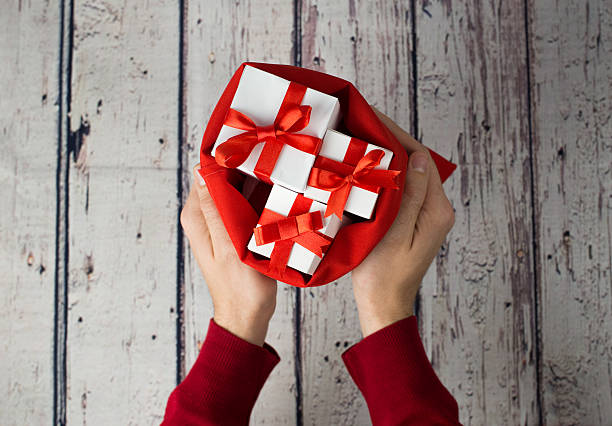 istock Man holding gift box on wood background 621107460