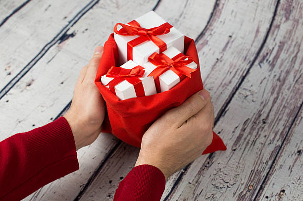 istock Man holding gift box on wood background 621107472