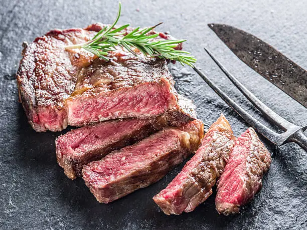 Medium Ribeye steak with spices on the graphite tray.