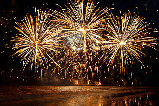 piękne złote fajerwerki nad morzem na nocnym niebie - new year zdjęcia i obrazy z banku zdjęć