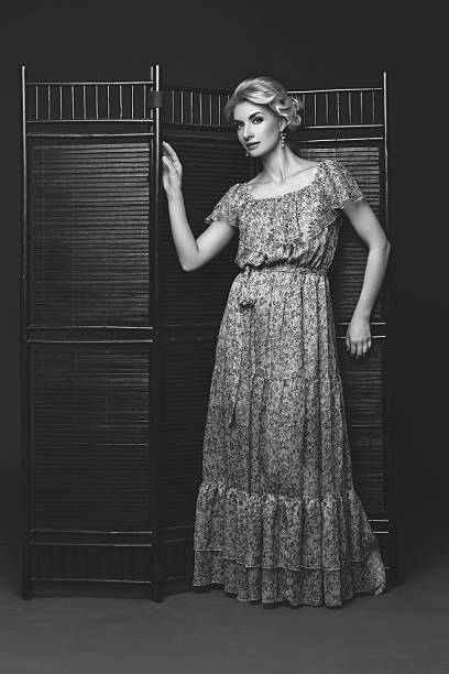istock Beautiful girl standing near folding screen 621114232
