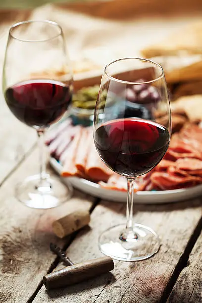 Red wine with charcuterie assortment on the background