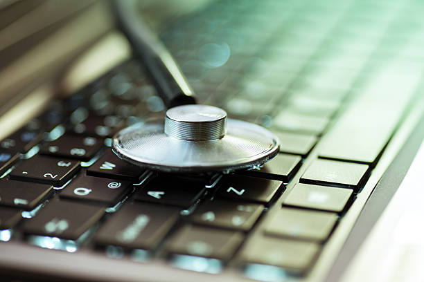 Stethoscope on laptop keyboard Stethoscope on laptop keyboard high quality and high resolution studio shoot debugging photos stock pictures, royalty-free photos & images