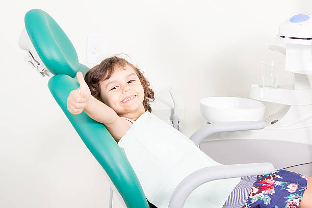 bonne petite fille mignonne à la clinique dentaire - dentist teenager dental hygiene sitting photos et images de collection