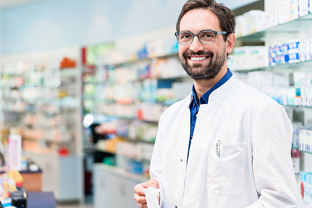 istock Apothecary in pharmacy standing at shelf with drugs 621119172