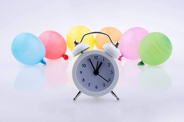 istock Alarm clock and colorful small Baloons 621120204