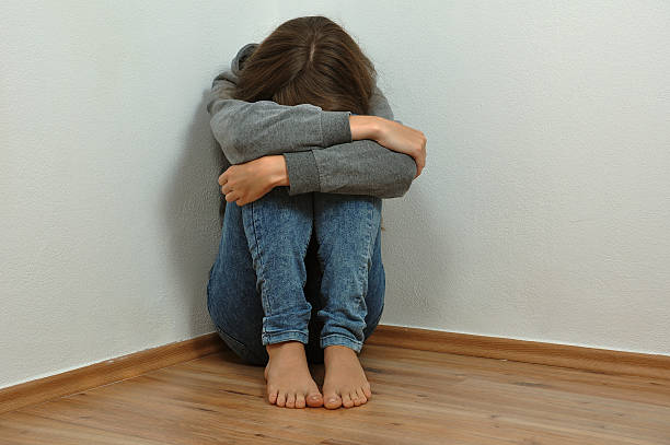 Lonely girl Lonely girl crying in the corner child abuse stock pictures, royalty-free photos & images