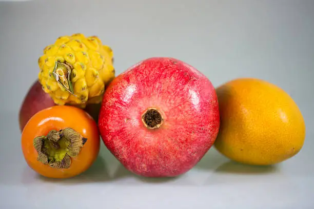 Exotic fruit, khaki, mango, pitahaja, pomegranate on a white background