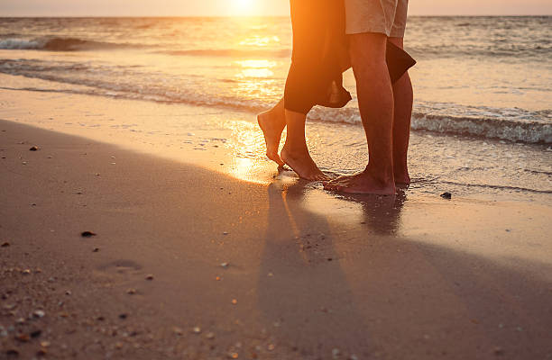 istock Love couple legs on sun rise sea side 621124824