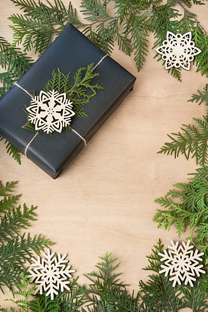 istock Christmas gift box in black paper on wooden surface. Copy-space. 621125656