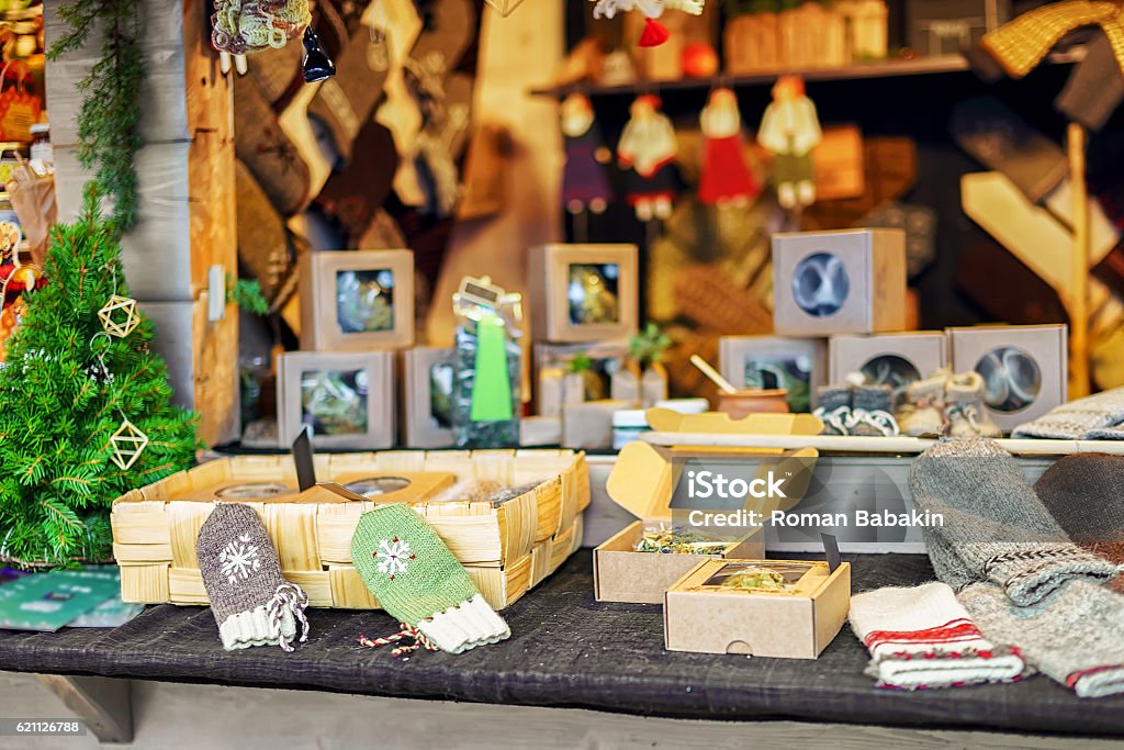 Knitted mittens and other souvenirs at the Riga Christmas market Handmade souvenirs and knitted gloves displayed for sale at the stand during the Christmas market in Riga, Latvia. The fair takes place each year from December till the beginning of January. Craft Stock Photo