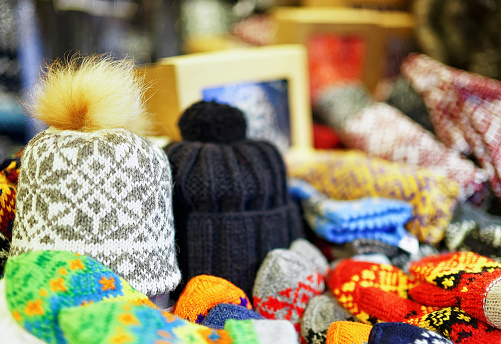 Two warm hats among other knitted clothes displayed for sale at the Christmas market in old Riga, Latvia. At this stand people can also buy festive mittens, gloves, scarfs and little toys for kids.