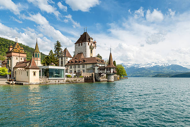 Beautiful little tower of Oberhofen castle in the Thun lake Thun , Switzerland - May 10, 2016: Beautiful little tower of Oberhofen castle in the Thun lake with mountains on background in Switzerland, near Bern. lake thun stock pictures, royalty-free photos & images