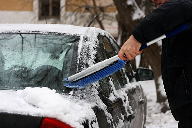 istock The man who cleans the car from snow. 621130344