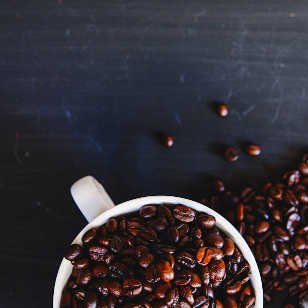 istock Overhead view of Roasted coffee bean in a white cup 621135428