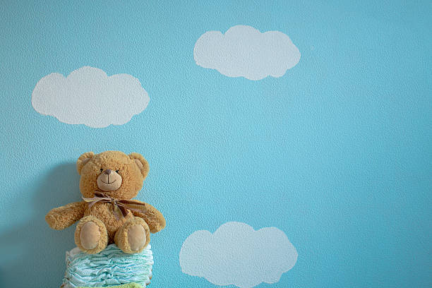 The toy is sitting on the diapers The toy is sitting on the diapers in the wall background of blue sky and clouds product designer photos stock pictures, royalty-free photos & images
