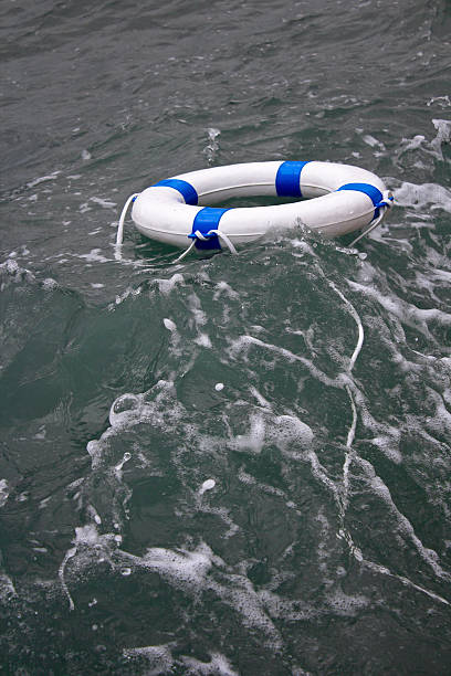 lifebuoy, cintura di vita in una pericolosa tempesta di mare come concetto di speranza - isolated despair hope assistance foto e immagini stock