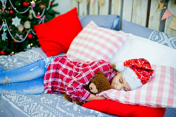 istock Little girl in red hat sleeping before Christmas 621140630