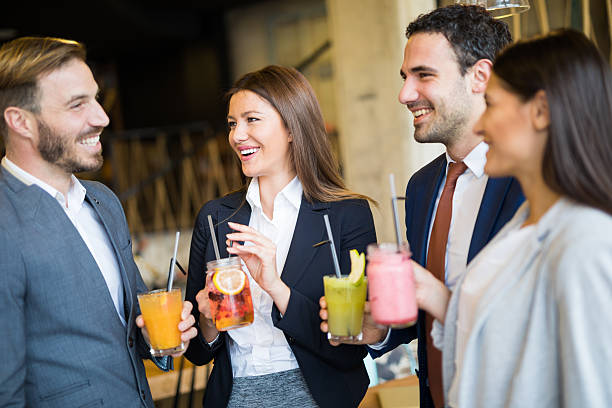 business team taking a break and drinking healthy smoothies - office fun group of people white collar worker imagens e fotografias de stock