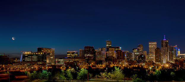 Skyline of Denver Colorado with moon at night