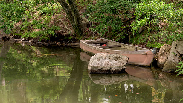 istock Classic old wood boat in a pond 621144418