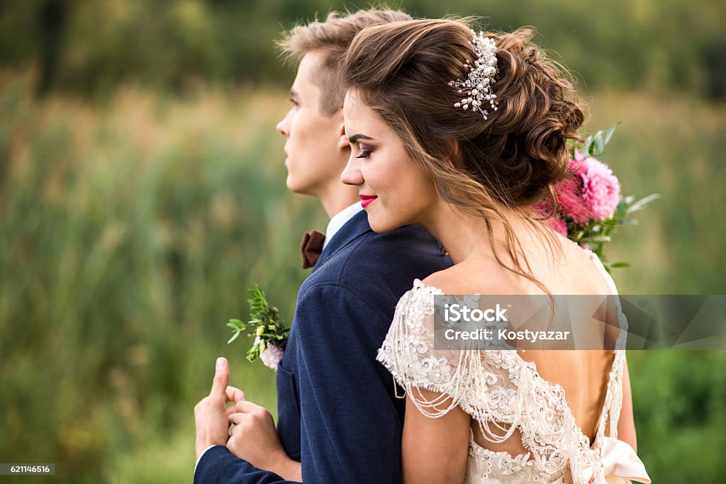 Bride and groom embracing in the park Happy bride and groom embracing in the park, wedding day Bride Stock Photo