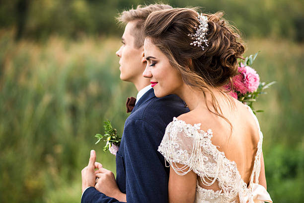 bride and groom embracing in the park - hairstyle love wedding photography imagens e fotografias de stock