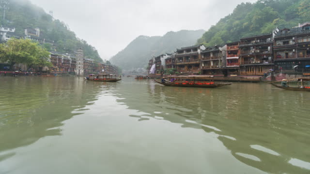 Time lapse of The ancient town of Fenghuang with traditional boats in rainy day