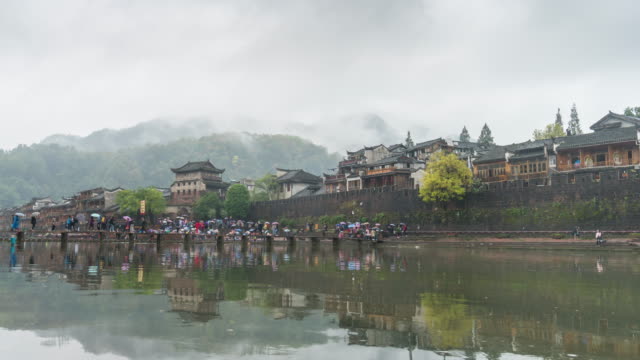 Time lapse of tourists walking across river at Fenghuang old town