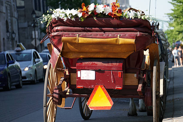 Back of an horse-drawn carriage Montreal, Canada - May 23, 2016: The back of a red carriage decorated with flowers. The horse-drawn carriage is waiting for tourist clients in Old Montreal. In May, the mayor backtracked on his decision to impose a year-long moratorium on the popular caleches. caleche stock pictures, royalty-free photos & images