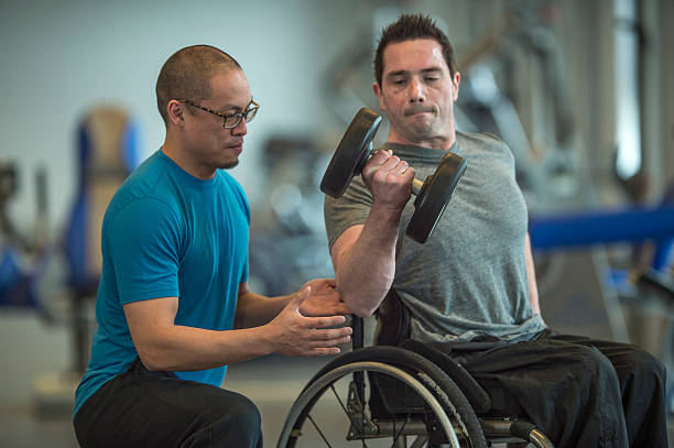 gewichte mit einem personal trainer heben - men chair wheelchair sport stock-fotos und bilder