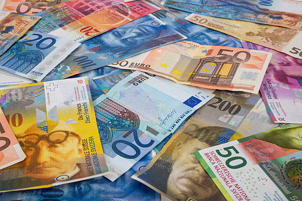 les billets en euros et en chf comme toile de fond - switzerland swiss currency chf euro symbol photos et images de collection