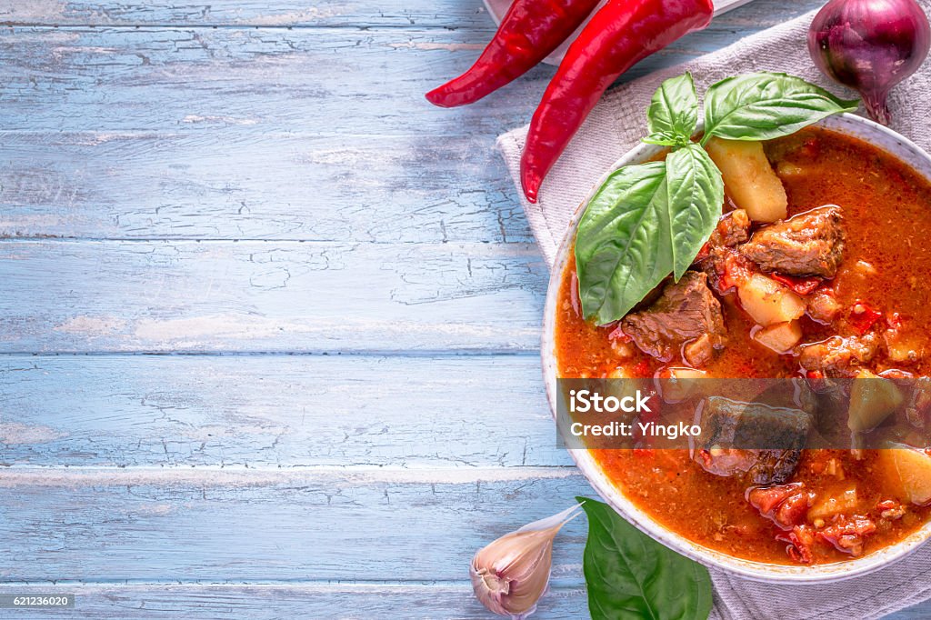 Hungarian goulash on cyan background with copy space Bowl of goulash on light cyan background with copy space. Traditional hungarian meal - beef stew.  Goulash Stock Photo