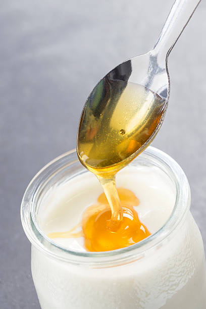 istock Yogurt and pouring honey on white background 621236178