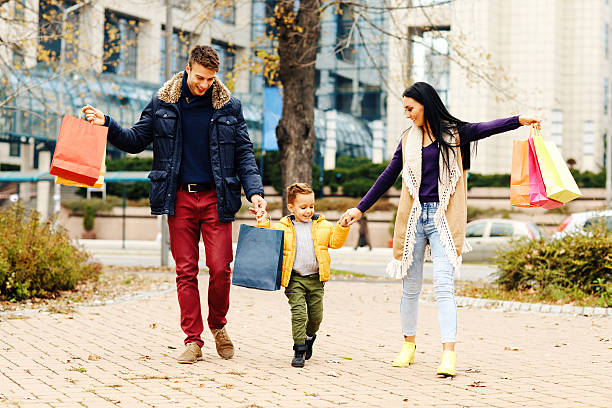 młoda szczęśliwa rodzina idąca ulicą po zakupach - couple autumn fashion male beauty zdjęcia i obrazy z banku zdjęć