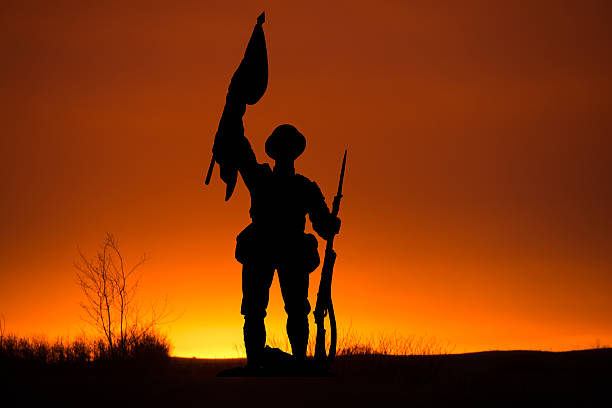 istock Sunset with silhouette of a soldier and flag copy space 621238210