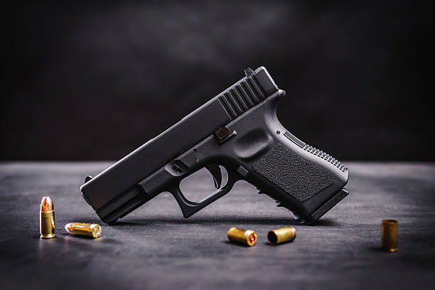 black pistol on a black table - handgun imagens e fotografias de stock