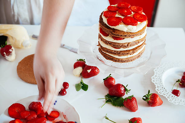 istock Woman Carefully Icing The Cake 621240380