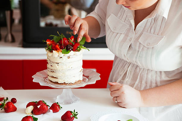 istock Woman Carefully Icing The Cake 621240924