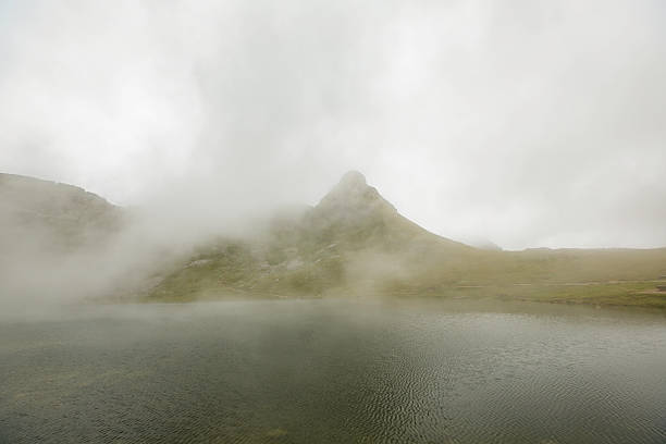 istock panoramic view of Alps mountains with lake, in the clouds 621241046